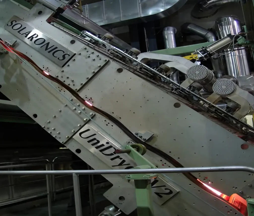 Close-up of an industrial UniDryer V2 unit labeled Solaronics in a production line.