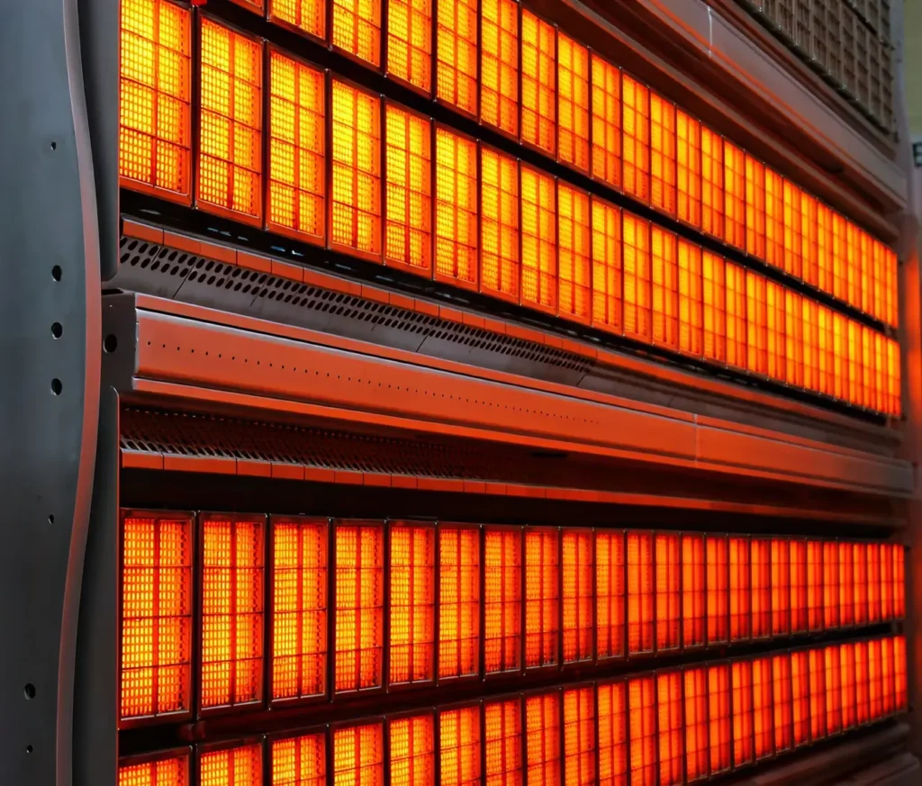 Close-up of industrial infrared heating panels glowing bright orange