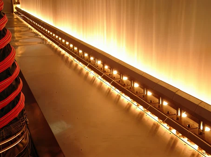 Row of lamps emitting light onto material in a continuous production system.