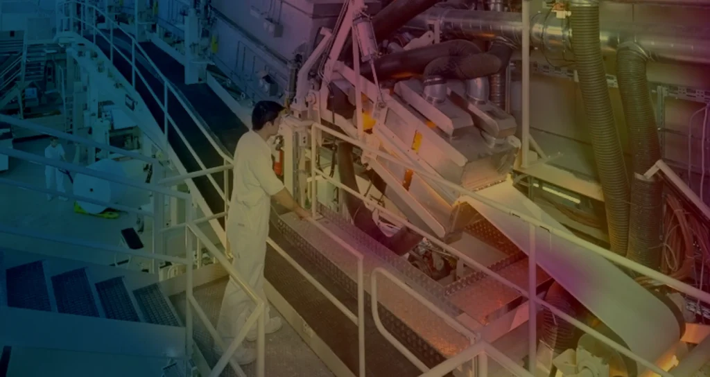 Technician monitoring industrial equipment in factory facility.