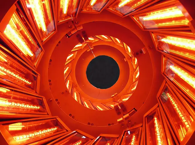 Interior view of a circular industrial infrared heating system glowing orange.